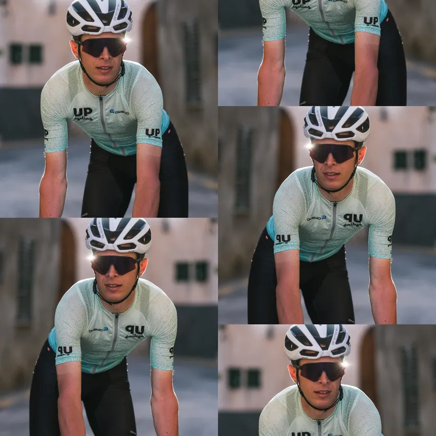 Ein Radfahrer in einem hellblauen, kurzärmligen Trikot und einer schwarzen Hose fährt auf einer sonnigen Straße.
